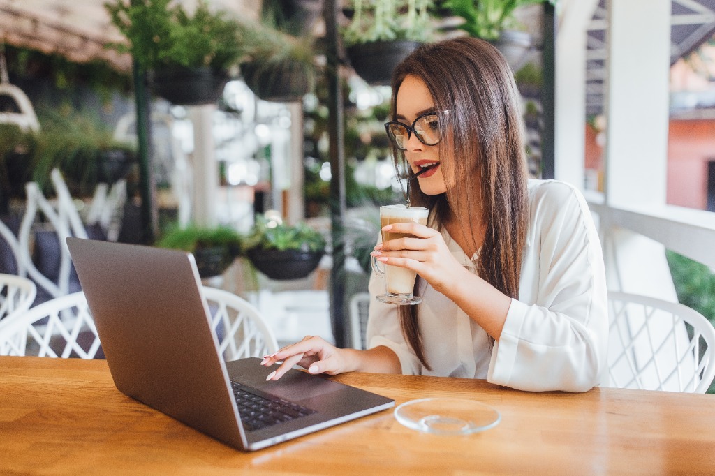 Mujer trabajando desde casa feliz con su computador